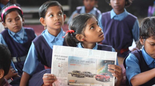 student holding a newspaper