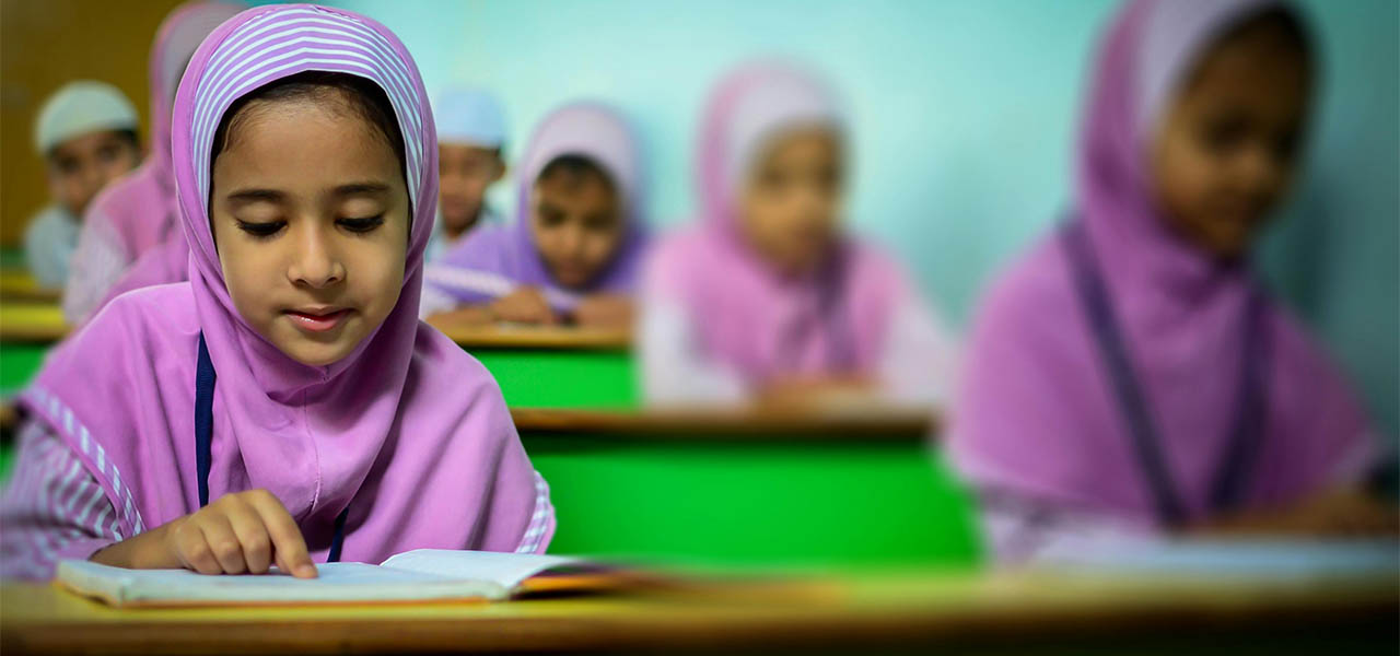 Group of young students in traditional hijabs focusing on their studies in a classroom